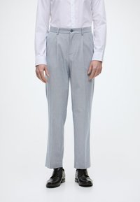 Ανοιχτό μπλε ριγωτό παντελόνι με χαλαρή εφαρμογή, που διαθέτει κλείσιμο με ένα κουμπί, θηλάκια για ζώνη και καλοστημένα πιεσμένα εμπρόσθια πτυχώσεις.