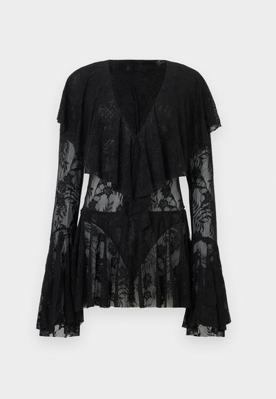 Μαύρη μακρυμάνικη μπλούζα από δαντέλα με βαθύ V-λαιμόκοψη, στρωμένη με βολάν μπροστά, με λουλουδάτο μοτίβο και φαρδιά μανσέτα σε απλό φόντο.