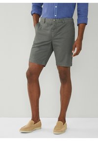 Grå bomulds shorts med flad frontdesign, sidelommer og knaplukning, parret med lysebrune slip-on sko.