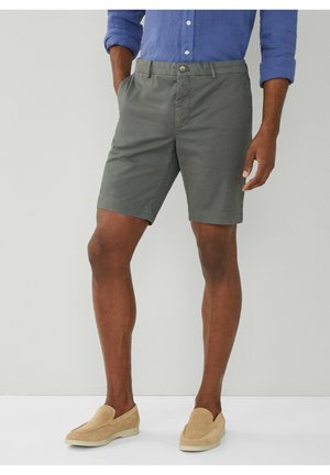 Grå bomulds shorts med flad frontdesign, sidelommer og knaplukning, parret med lysebrune slip-on sko.