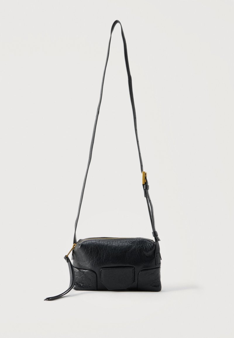 Μαύρη τσάντα χιαστί από υφή δέρματος με ρυθμιζόμενο λουράκι, χρυσή πόρπη και κλείσιμο με φερμουάρ, εμφανιζόμενη σε απλό λευκό φόντο.