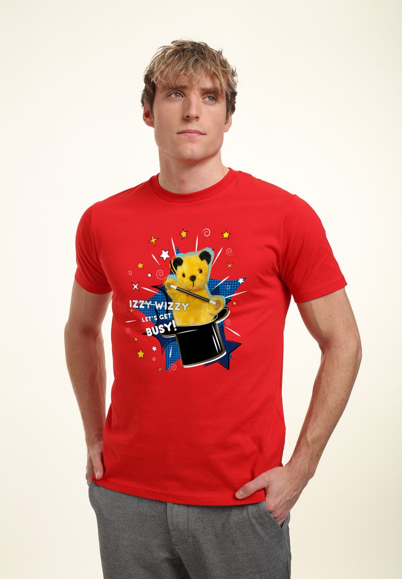 Rød bomulds T-shirt med et tegneserie-bjørn, der popper op af en sort tryllehat, prydet med farverige stjerneaccentuer og teksten "IZZY-WIZZY LAD OS KOMME I GANG!"