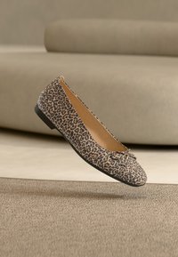 Μπαλαρίνα με λεοπάρ σχέδιο, στρογγυλερή μύτη και μικρή λεπτομέρεια φιόγκου στη γλώσσα. Μαλακό ύφασμα στο επάνω μέρος και μαύρη ελαστική σόλα.