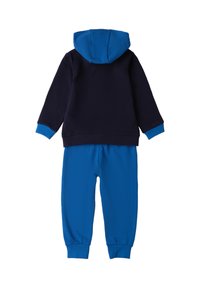 Chándal de algodón azul y marino que cuenta con capucha, puños acanalados y puños en los tobillos. La parte superior tiene un cuerpo sólido en color marino con acentos azules en contraste.