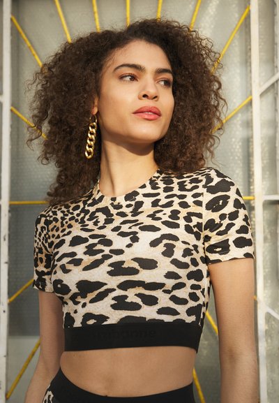 T-shirt corta de padrão de leopardo em bege e preto, com gola redonda e mangas curtas. A cintura preta apresenta detalhes com o logótipo.
