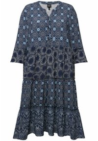 Largo vestido azul marino con un diseño de volantes, con patrones de flores azules y lunares, escote abotonado y mangas amplias. Textura de tela suave.