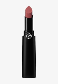 Un lápiz labial en un tubo negro elegante, con una punta afilada. El color es un rosa apagado con un acabado mate suave y un acento de logo.