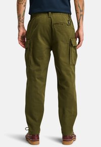 Pantalones cargo verde oliva con bolsillos laterales, fabricados con tela duradera. Presenta una cinturilla ajustada y detalles cosidos en los bolsillos traseros.