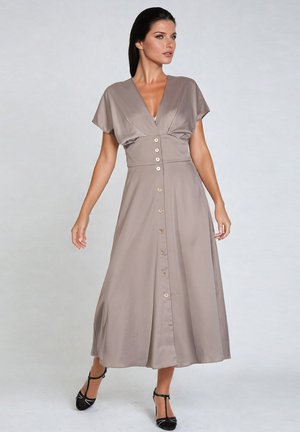 Robe midi en tissu taupe avec des manches courtes, un décolleté en V profond et des détails de boutons sur le devant. Texture lisse avec une silhouette fluide.