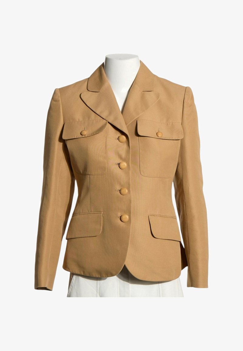 Blazer ajusté couleur camel avec quatre boutons sur le devant, deux poches poitrine à rabat avec boutons, et deux poches inférieures à rabat sur un mannequin blanc.