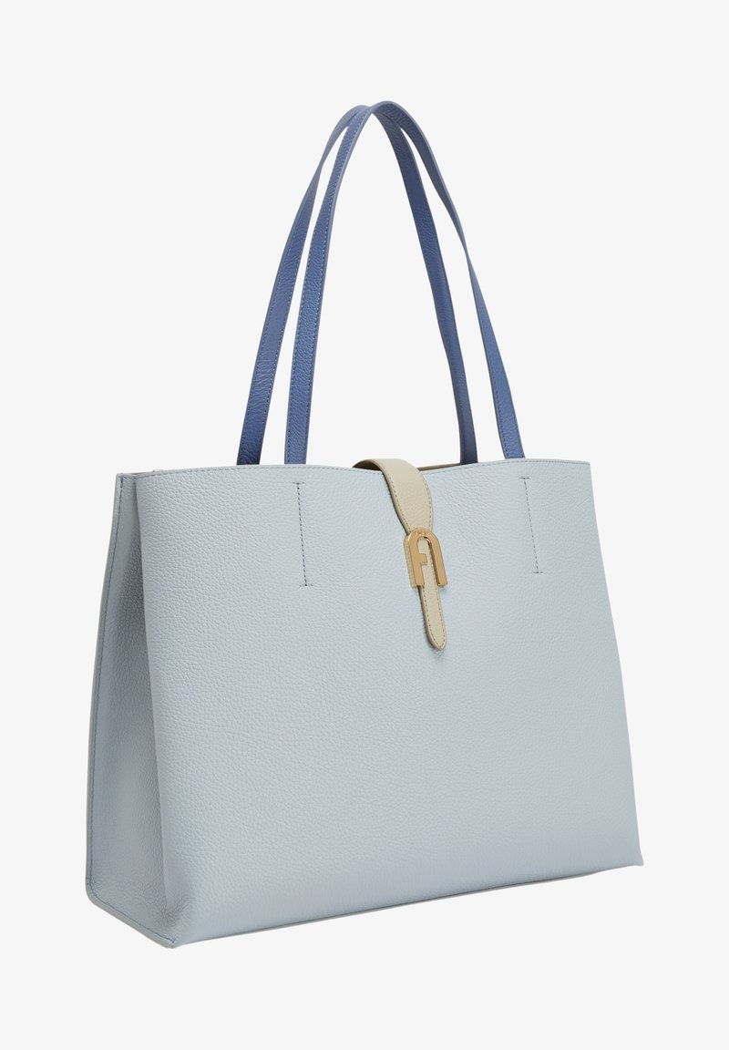 Sac fourre-tout en cuir texturé bleu clair avec de longues poignées bleu foncé et une sangle beige avec boucle en métal doré.