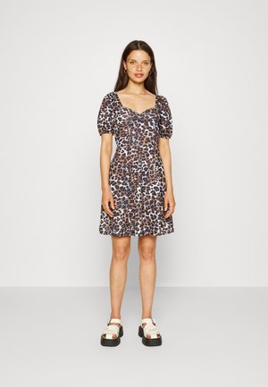 Vestido de estampa de leopardo com mangas bufantes, decote quadrado e saia rodada. Feito de um tecido leve. Combinado com sandálias brancas robustas.