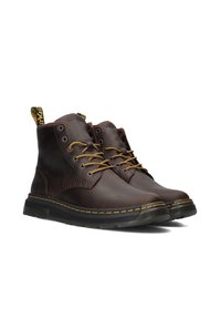 Brown leather ankle boots with yellow stitching, round toe, leather laces, and a pull tab. Lightweight rubber sole and textured accents.
