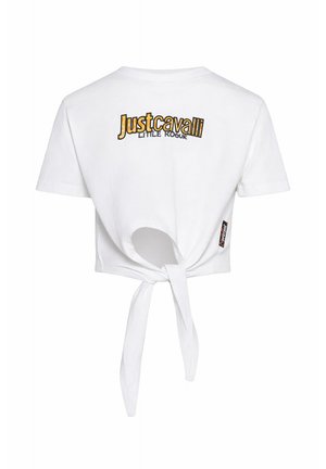 Crop top blanc à manches courtes avec lien dans le dos, avec le texte « Just Cavalli Little Rogue » en jaune et noir sur la partie supérieure du dos.