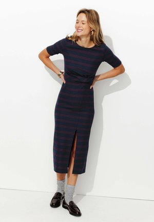 Robe rayée en marine avec des lignes bordeaux, longueur genou avec une fente sur le côté. Tissu doux, encolure ronde, forme ajustée, manches courtes.