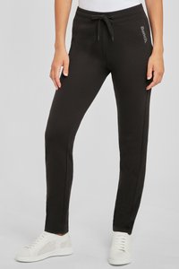 Schwarze Jogginghose im Slim-Fit, mit einem gerippten Bund mit verstellbarem Kordelzug und Seitentaschen. Auffälliges Logo-Detail an der Hüfte.