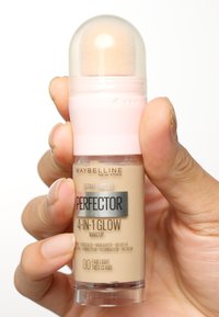Maquillage Maybelline 4-en-1 Glow dans un flacon en plastique transparent, avec un bouchon rose arrondi et un applicateur en éponge sur le dessus. Couleur : clair léger.