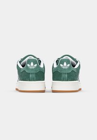 Sneakers in camoscio verde con accenti bianchi, design strutturato e suola in gomma color naturale. Presentano un logo sul tallone e una punta rotonda classica.