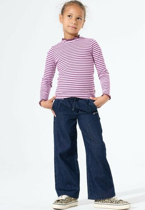 Maglietta a maniche lunghe a righe viola con scollo arricciato, abbinata a pantaloni in denim a gamba larga blu scuro e sneakers con stampa leopardata.
