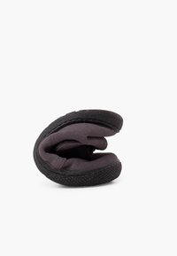 Zapatos negros flexibles con una parte superior suave y texturizada y una suela de goma. El diseño permite un fácil plegado y almacenamiento.