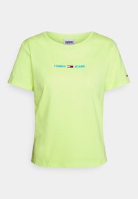 Neongrön bomull t-shirt med rund halsringning, korta ärmar och "TOMMY JEANS"-logotyp i blått med röda och vita accentlinjer.