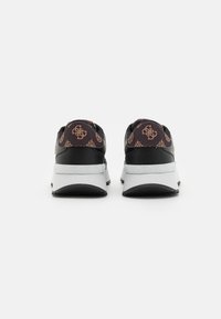 Sneakers neri con tomaia a motivo e dettagli dorati, dotati di una suola bianca chunky. Pelle strutturata sul retro e ai lati.