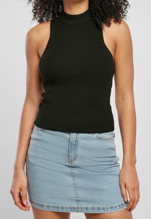 Zwart geribd mouwloos topje met hoge hals, gecombineerd met een lichtblauwe denim minirok met een voorsplit en standaard tailleband.