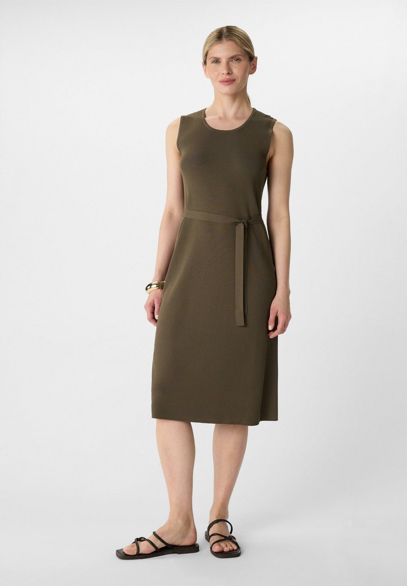 Olivengrünes ärmelloses Kleid mit taillierter Oberpartie, breitem Taillenbund und gebundenem Gürtel. Glatte Textur mit einem knielangen Rock.