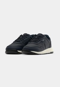 Paire de baskets bleu marine à lacets avec semelles blanches, design bas et un discret logo « BOSS » sur le côté et la semelle.