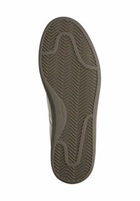 Sole della scarpa con una texture ondulata, materiale in gomma marrone chiaro e una leggera curvatura verso l'alto nella punta per flessibilità e aderenza.
