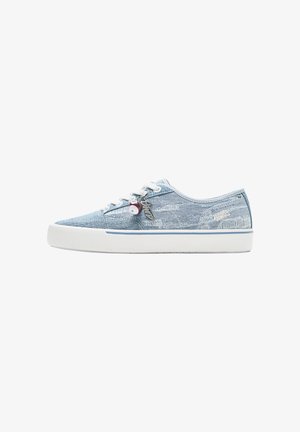 Lage sneaker in lichtblauw denim met witte rubberen zool, witte veters en decoratieve hangertjes die aan de zijkant van de veterogen hangen.
