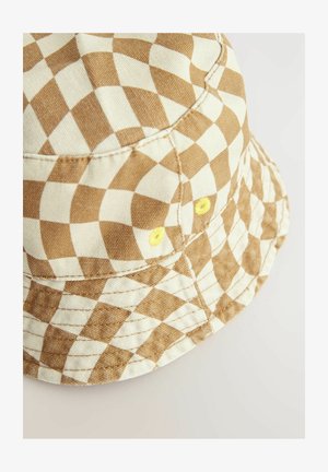 Barna és krém színű kockás vödörkalap, texturált anyagból készült, sárga fémlyukakkal és ferde karimával.