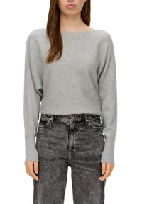 Hellgrauer gerippter Pullover mit weitem Ausschnitt und langen Ärmeln, kombiniert mit hochgeschnittenen, dunkelgrauen Jeans.