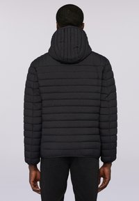 Svart puffjacka med ribbad huva och horisontellt quiltat mönster, utrustad med långa ärmar och rak fåll.