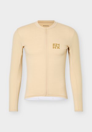 Beige fietstrui met lange mouwen, volledige ritssluiting aan de voorkant en een klein goudkleurig "ENDURA" logo op de linkerborst.