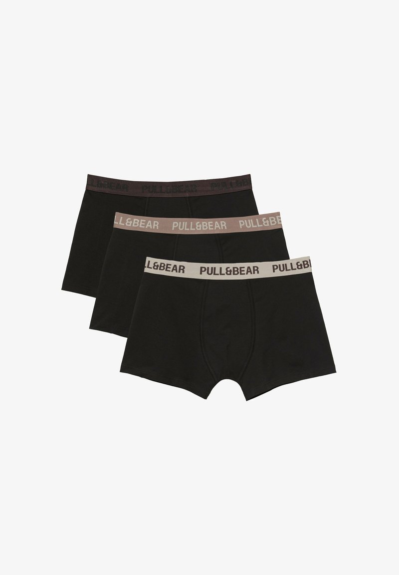 Trois boxers noirs pour hommes avec des ceintures élastiques de différentes couleurs, chacun marqué du texte "PULL&BEAR."