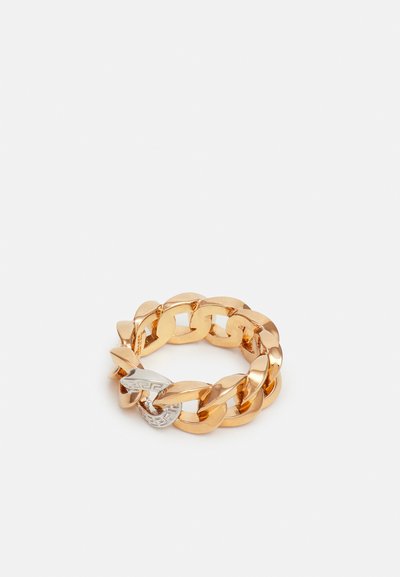 Bague en chaîne ton or avec des maillons entrelacés et polis, ornée d'un accent en argent. Détails avec une section texturée et une finition lisse.