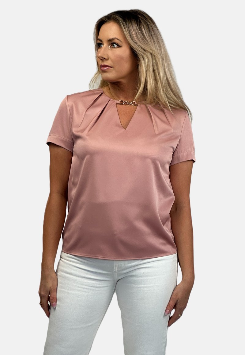 Short-sleeve, light pink blouse with a V-neck and pleated detailing at the shoulders, featuring a silver chain accent at the neckline.
