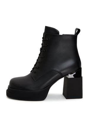 Zwarte veterschoenen tot de enkel, gemaakt van soepel leer, met een stevige vierkante hak en een glanzend accent op de hak. Rond neusdesign.
