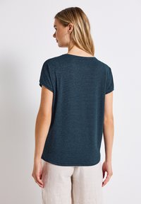 Mørkeblå kortærmet t-shirt med et diskret stripet mønster og en rund halsudskæring, lavet af et blødt, struktureret stof.
