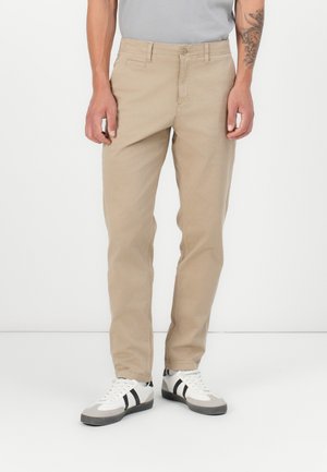 Pantalons en toile de coton beige avec une coupe droite, présentant un design classique à cinq poches et une fermeture à bouton à la taille.