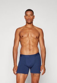 Marineblauwe boxershorts van zacht katoen, met een brede elastische tailleband met het "GAP" logo en een aansluitend ontwerp voor comfort.