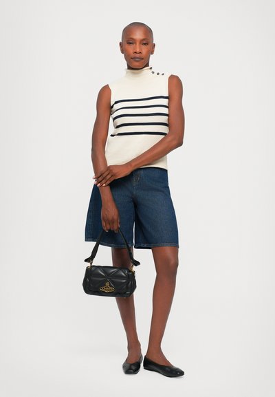 Top beige senza maniche con strisce navy e bottoni decorativi, abbinato a pantaloni corti in denim scuro e una borsa a tracolla nera trapuntata. Scarpe ballerine nere.