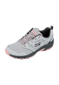 Zapatilla deportiva gris claro con acentos en rosa, parte superior de malla, cuello acolchado y suela de goma texturizada con tacos de tracción multidireccional.