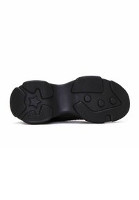 Black sneaker sole with textured rubber. Features grooves and round traction points. Star shape design detail near the arch for grip.