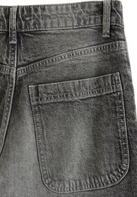 Czarne dżinsy z widoczną tylnią kieszenią, z detalami szwów oraz teksturowanym wykończeniem. Wyblakły wygląd dodaje głębi projektowi.