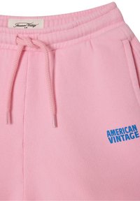 Roze joggingbroek met verstelbare trekkoord, met een blauw "AMERICAN VINTAGE" logo. Zachte textuur en een ontspannen pasvorm.