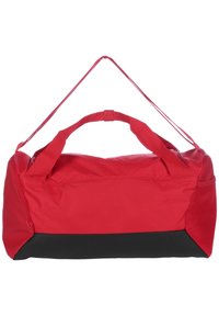 Red duffel bag with padded handles, black base, and smooth texture. Features a top zipper and side mesh pocket for additional storage.