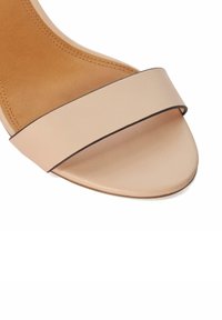 Blush leather slide sandal with a wide strap and a flat sole. Minimalist design featuring a smooth finish and subtle contrasting edge.