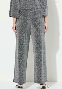 Grijze, gestructureerde wijde broek met verticale strepen. Zachte stof, elastische tailleband en lengte tot aan de enkels.